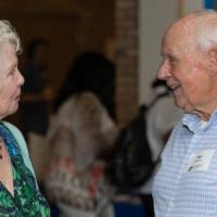 Two people talking in shades of blue clothing
